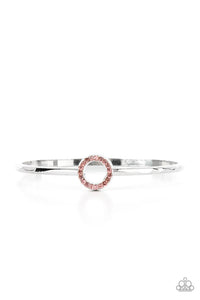 Brilliant dainty pink rhinestones set in a shiny silver round frame, create a glitzy circle in the center of a subtly hammered silver bangle.  Sold as one individual bracelet.