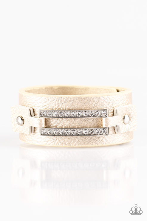 Encrusted in glittery white rhinestones, a glistening silver frame is studded in place across the front of a metallic gold band for an edgy look. Features an adjustable snap closure.  Sold as one individual bracelet.