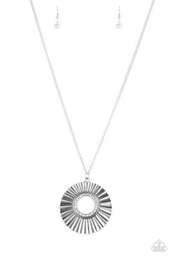 Brushed in a gritty antiqued finish, a rippling silver frame flares from a white rhinestone encrusted center for an edgy look. Features an adjustable clasp closure. Sold as one individual necklace. Includes one pair of matching earrings.