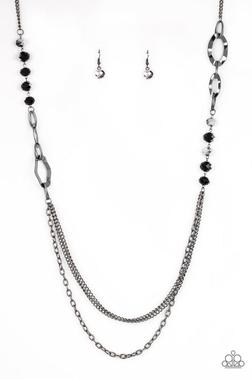 Dipped in metallic shimmer, a collection of black crystal-like beads and hammered gunmetal frames give way to layers of mismatched gunmetal chains for a modern look. Features an adjustable clasp closure.  Sold as one individual necklace. Includes one pair of matching earrings.