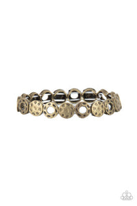 A rustically hammered collection of brass rings and discs are threaded along stretchy bands around the wrist, creating a dainty metallic centerpiece.  Sold as one individual bracelet.