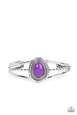 An asymmetrical purple bead is encircled with a textured silver frame atop a decorative silver cuff, resulting in a colorful tribal inspired centerpiece around the wrist.  Sold as one individual bracelet.