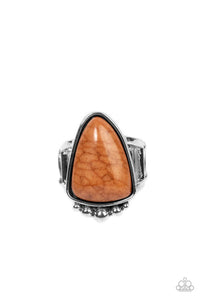 An asymmetrical triangular Adobe stone is pressed into an antiqued silver frame dotted in a single row of silver studs, creating an artisan inspired pop of color atop two silver bands. Features a stretchy band for a flexible fit.  Sold as one individual ring.