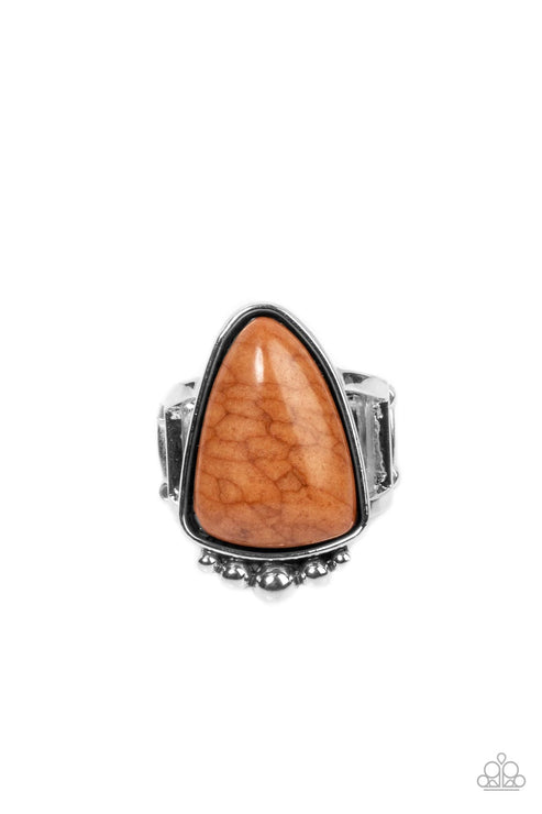 An asymmetrical triangular Adobe stone is pressed into an antiqued silver frame dotted in a single row of silver studs, creating an artisan inspired pop of color atop two silver bands. Features a stretchy band for a flexible fit.  Sold as one individual ring.