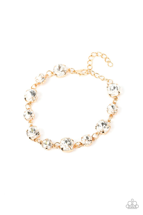 Varying sizes of stunning white rhinestones set in gold pronged settings delicately link together around the wrist, creating a glassy strand of swoon-worthy style. Features an adjustable clasp closure.  Sold as one individual bracelet.