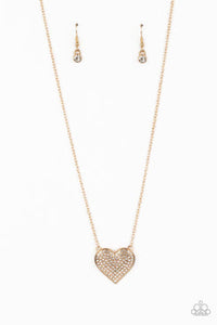 A heart-shaped pendant in a gold finish is anchored between two strands of delicate chain in the same reflective finish. The interior of the heart is filled with glittery white rhinestones, inviting onlookers to admire its unflinching sparkle. Features an adjustable clasp closure.  Sold as one individual necklace. Includes one pair of matching earrings.