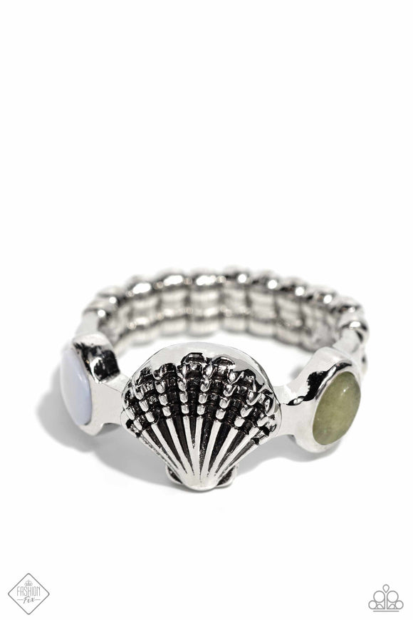 Centered along a thin silver band, a detailed silver seashell glimmers beside a teardrop white shell and teardrop light green stone for a charming coastline centerpiece. Features a dainty stretchy band for a flexible fit. As the stone elements in this piece are natural, some color variation is normal. Sold as one individual ring.