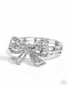 Infused along elastic stretchy bands, airy silver frames gleam along the wrist for a monochromatic display. Encrusted in white rhinestones, an oversized, airy silver bow glitters at the center of the design for a touch of class and refinement.  Sold as one individual bracelet.