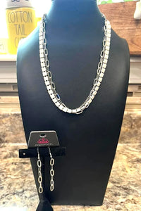 A medley of silver chains is joined by a strand of interlocking squares that are dipped in a vibrant white hue for a vibrant pop of industrial color around the collar. Features an adjustable clasp closure.  Sold as one individual choker necklace. Includes one pair of matching earrings. Choker