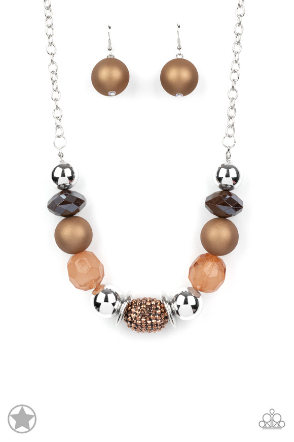 Warm beads in shades of brown and copper with reflective faceted edges and varying glazed finishes are offset by two shiny silver beads. An oblong bead studded with copper-toned rhinestones adds a dramatic accent. Features an adjustable clasp closure.  Sold as one individual necklace. Includes a matching set of earrings.