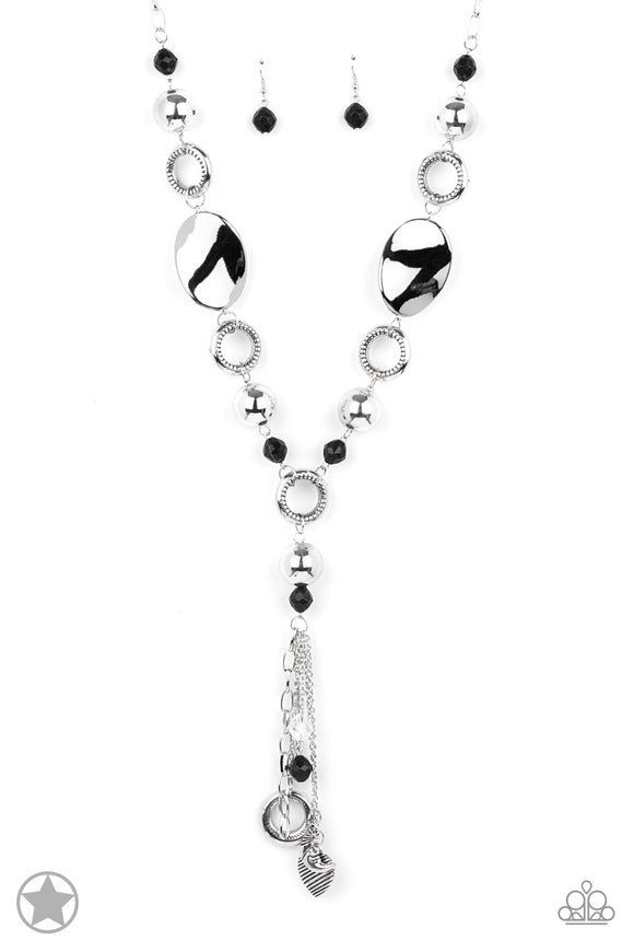 Long chain of black crystalized beads, curved plates of silver with a pearly finish, and chunky silver rings lead down to a tassel of chains and charms, including a crescent moon and a heart.  Sold as one individual necklace. Includes one pair of matching earrings.