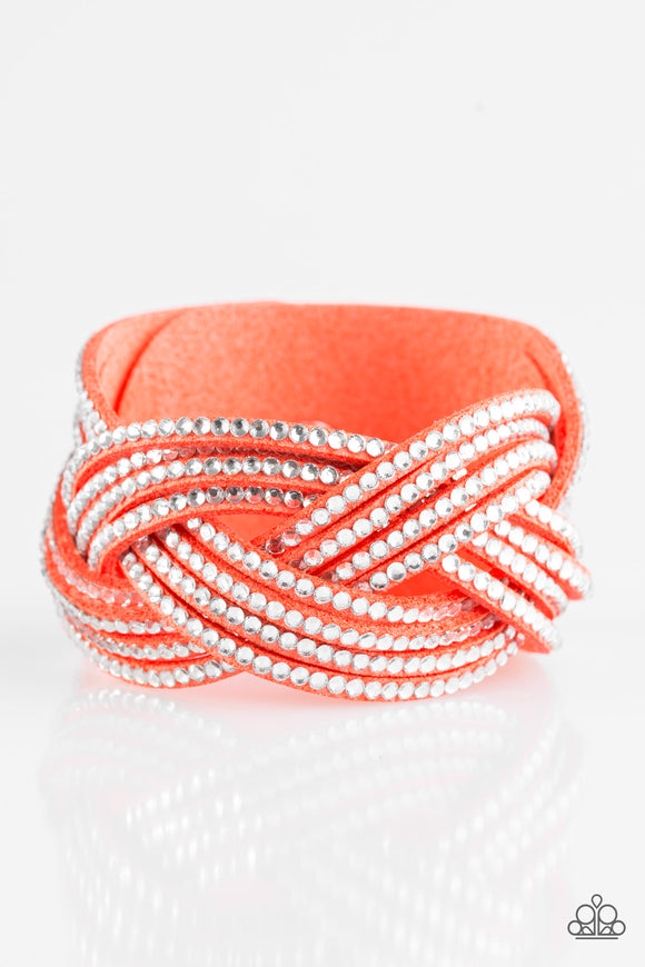 Glassy white rhinestones are encrusted along crisscrossing strands of coral suede, creating bold shimmer around the wrist. Features an adjustable snap closure.  Sold as one individual bracelet.