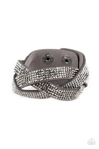 Encrusted in row after row of glittery hematite rhinestones, three gray suede bands braid across the wrist for a sassy look. Features an adjustable snap closure.  Sold as one individual bracelet.