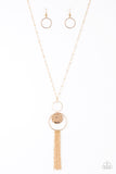 A delicately hammered gold disc is stamped in the inspirational word, "faith" and suspended from a double-hooped pendant at the bottom of an elongated gold satellite chain. A gold tassel swings from the bottom of the shimmery palette for a whimsical finish. Features an adjustable clasp closure.  Sold as one individual necklace. Includes one pair of matching earrings.