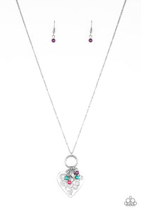 Infused with dainty multicolored pearls and a shimmery silver heart charm, a stenciled silver heart pendant swings from the bottom of a lengthened silver chain for a whimsical look. Features an adjustable clasp closure.  Sold as one individual necklace. Includes one pair of matching earrings.