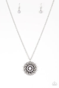 Neutral gray beads are sprinkled along ornate silver petals, creating a colorful floral frame. The whimsical pendant swings from the bottom of a lengthened silver chain for a seasonal look. Features an adjustable clasp closure. Sold as one individual necklace. Includes one pair of matching earrings.