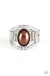 A pearly brown bead sits between two white rhinestone encrusted bands, creating the illusion of a floating centerpiece. Features a stretchy band for a flexible fit.  Sold as one individual ring.