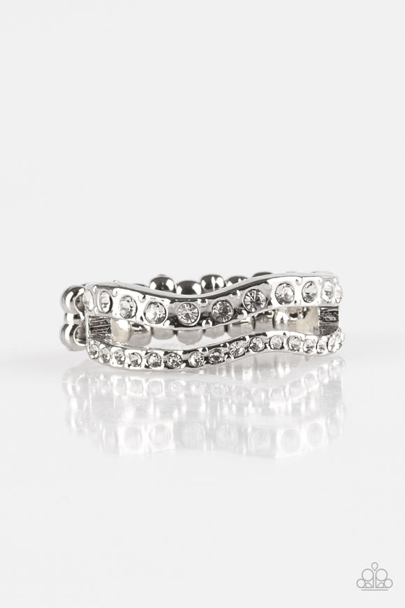 Varying in size, glittery white rhinestones are encrusted along waving silver bands for a refined look. Features a dainty stretchy band for a flexible fit.  Sold as one individual ring.