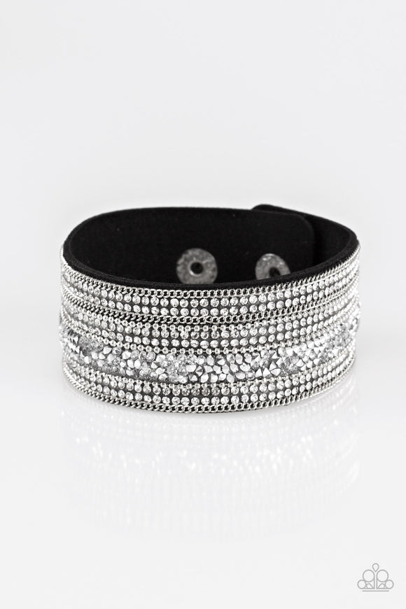 Rows of shimmery silver chains, glassy white rhinestones, and metallic prism rhinestones are sprinkled along a thick black suede band for a sassy style. Features an adjustable snap closure.  Sold as one individual bracelet.