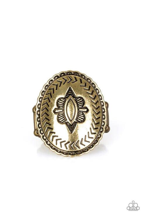 Stamped in tribal inspired patterns, a textured brass frame features a decorative floral center for an artisan inspired style. Features a stretchy band for a flexible fit. Sold as one individual ring.