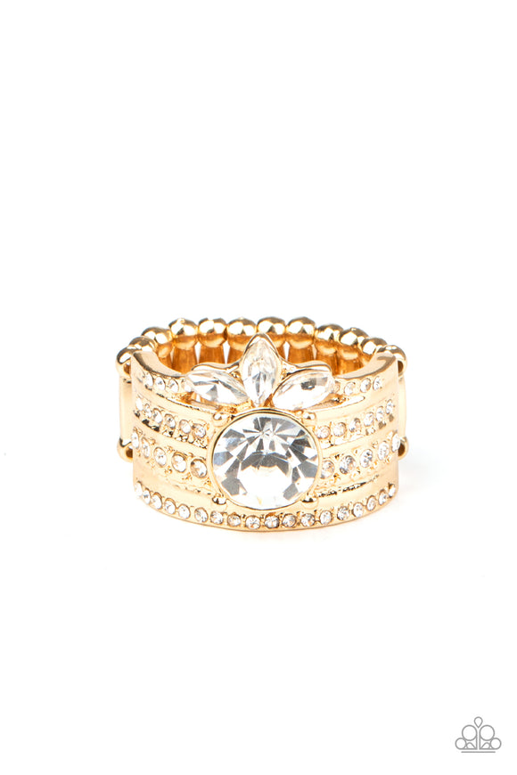 Varying in size, rows of dainty white rhinestones are encrusted along a thick gold band. Round and marquise rhinestones are pressed into the band, creating a refined centerpiece. Features a stretchy band for a flexible fit.  Sold as one individual ring.