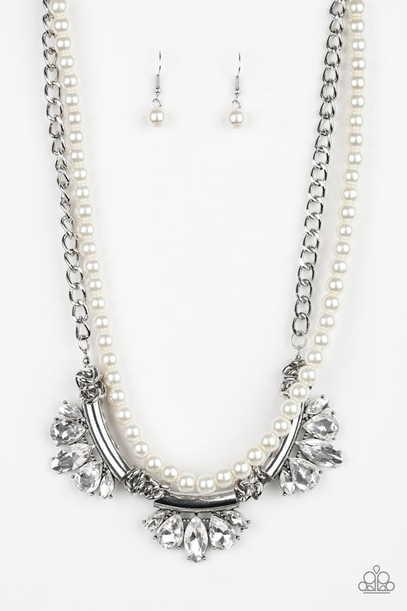 A classic strand of white pearls and dramatic silvery chain drape below the collar. Infused with heavy metal accents, teardrop and marquise cut white rhinestone frames connect into a show-stopping fringe. Features an adjustable clasp closure.  Sold as one individual necklace. Includes one pair of matching earrings.