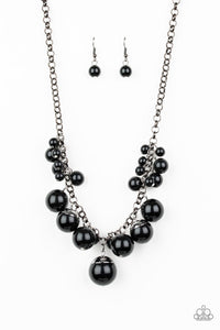 Capped in glistening gunmetal fittings, oversized black beads and a collection of classic black beads swing from the bottom of a shimmery gunmetal chain, creating a bubbly fringe below the collar. Features an adjustable clasp closure.  Sold as one individual necklace. Includes one pair of matching earrings.