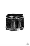 Infused with strands of smoky hematite rhinestones and dainty metallic accents, row after row of shimmery sequins are stitched across the front of a spliced black suede band. Bracelet features reversible sequins that change from black to silver. Features an adjustable snap closure.  Sold as one individual bracelet.