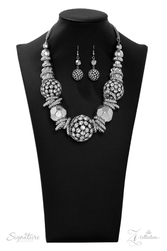 Large beads dusted in sparkle collide with silver hoops and beads in this jaw-dropper. The metallic accents increase in size towards the center, resulting in a statement piece that demands a doubletake. Features an adjustable clasp closure. Named after 2019 Rock the Runway winner, Barbara E.  Sold as one individual necklace. Includes one pair of matching earrings.