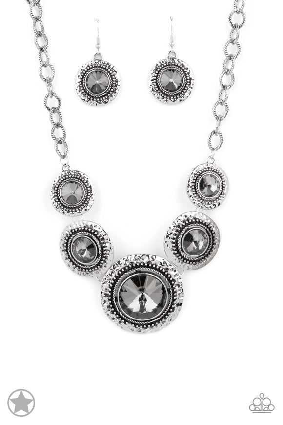 Gradually increasing in size, dramatically oversized smoky gems are pressed into the centers of hammered and silver studded frames. The blinding frames link below the collar for a glamorous, statement-making finish. Features an adjustable clasp closure.  Sold as one individual necklace. Includes one pair of matching earrings.