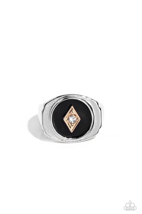A solitaire white rhinestone is pressed into the center of a gold diamond-shaped frame that sits atop a painted black backdrop. Features a stretchy band for a flexible fit.  Sold as one individual ring.