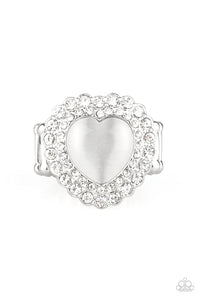 Chiseled into a charming heart shape, a glowing white cat's eye stone is pressed into the center of two silver heart frames radiating with glassy white rhinestones, creating a sparkling centerpiece atop the finger. Features a stretchy band for a flexible fit.  Sold as one individual ring.