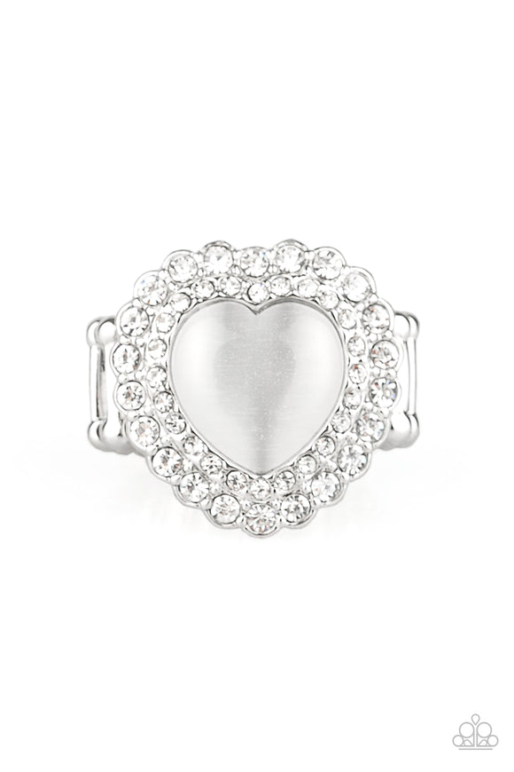 Chiseled into a charming heart shape, a glowing white cat's eye stone is pressed into the center of two silver heart frames radiating with glassy white rhinestones, creating a sparkling centerpiece atop the finger. Features a stretchy band for a flexible fit.  Sold as one individual ring.