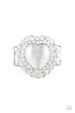 Chiseled into a charming heart shape, a glowing white cat's eye stone is pressed into the center of two silver heart frames radiating with glassy white rhinestones, creating a sparkling centerpiece atop the finger. Features a stretchy band for a flexible fit.  Sold as one individual ring.