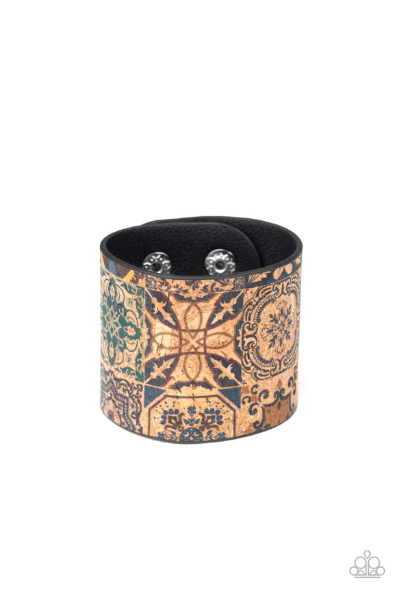 Painted in a tiled textile pattern, a thick cork-like leather band wraps around the wrist for a statement-making look. Features an adjustable snap closure.  Sold as one individual bracelet.