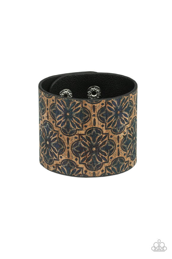 Painted in a regal blue floral pattern, a thick cork-like leather band wraps around the wrist for a statement-making look. Features an adjustable snap closure.  Sold as one individual bracelet.