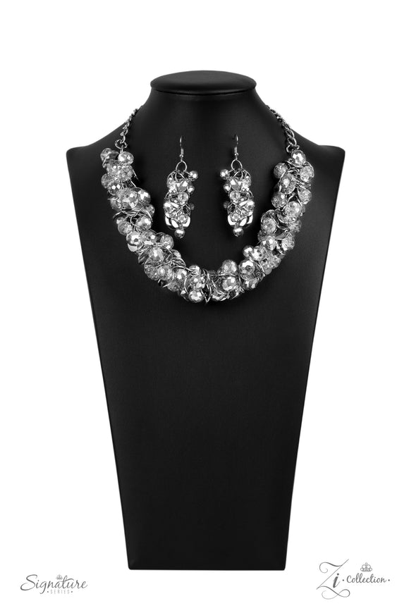 A brazen collection of metallic dipped crystal-like beads and delicately bent silver discs boldly cluster into a fearless fringe below the collar. The exaggerated display of jam-packed sparkle takes glitter to a whole new level with its unapologetic attitude. Features an adjustable clasp closure.  Named after 2020 Rock the Runway winner, Haydee, F.  Sold as one individual necklace. Includes one pair of matching earrings.