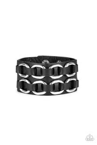 Black leather laces thread through two rows of bold silver links across the front of a thick black leather band for a gritty look. Features an adjustable snap closure.  Sold as one individual bracelet.