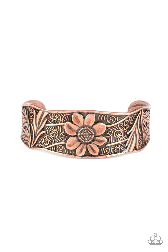 The front of an asymmetrical copper cuff is stamped and embossed in lacy vines and a leafy floral pattern for a whimsical fashion.