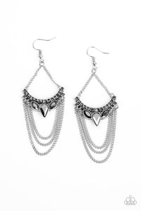 Tiers of shimmery silver chains swing from the bottom of a bowing silver frame encrusted in an array of smoky hematite rhinestones. Suspended by matching silver chains, the glittery frame coalesces into an edgy chandelier. Earring attaches to a standard fishhook fitting.  Sold as one pair of earrings.