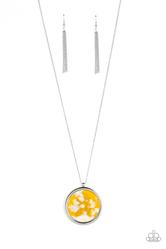 Featuring a yellow and white tortoise shell pattern, a flat acrylic circle is pressed into a sleek silver ring, creating a colorfully retro pendant at the bottom of a lengthened silver chain. Features an adjustable clasp closure.  Sold as one individual necklace. Includes one pair of matching earrings.