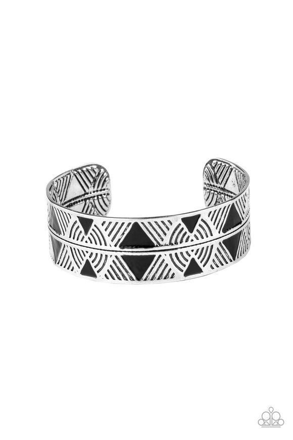 Painted in shiny black triangular accents, a thick silver cuff embossed in a dizzying linear pattern has been spliced down the center for a tactile finish.  Sold as one individual bracelet.