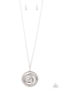 Encrusted in sections of glittery white rhinestones, glistening silver bars swirl inside a white rhinestone encrusted circle, creating a dizzying pendant at the bottom of a lengthened silver chain. Features an adjustable clasp closure.  Sold as one individual necklace. Includes one pair of matching earrings.