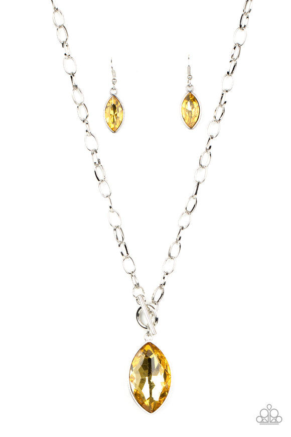 Featuring a regal marquise style cut, a dramatically oversized golden yellow rhinestone swings from a chunky silver chain, creating a gorgeous pendant below the collar. Features a toggle closure.  Sold as one individual necklace. Includes one pair of matching earrings.