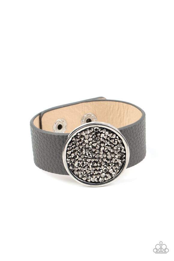 A smoldering display of hematite rhinestones scatter across the front of a silver disc that glides along a gray leather band for a stellar look. Features an adjustable snap closure.  Sold as one individual bracelet.