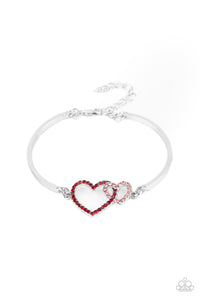 Encrusted in dainty red and pink rhinestones, a charming pair of interlocking heart frames attach to two silver bars around the wrist, creating a flirty bangle-like bracelet. Features an adjustable clasp closure.  Sold as one individual bracelet.