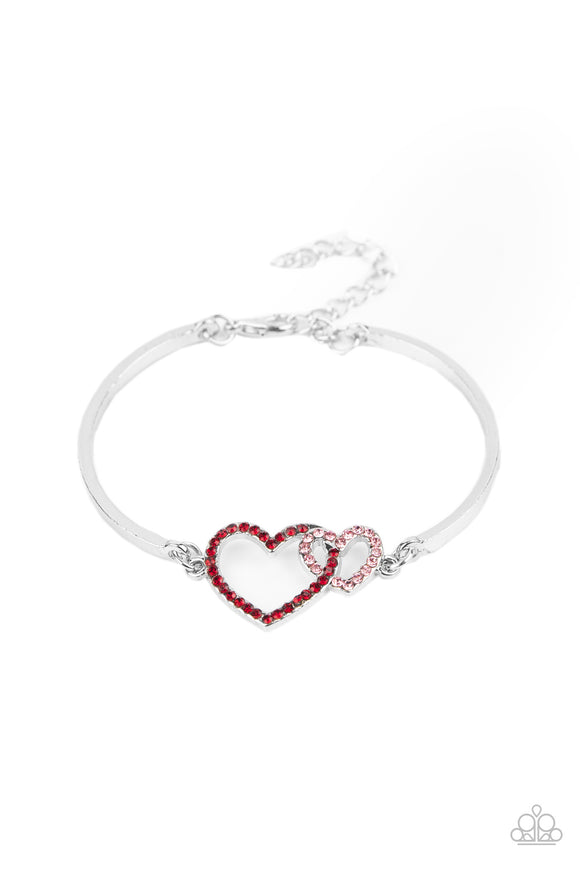 Encrusted in dainty red and pink rhinestones, a charming pair of interlocking heart frames attach to two silver bars around the wrist, creating a flirty bangle-like bracelet. Features an adjustable clasp closure.  Sold as one individual bracelet.