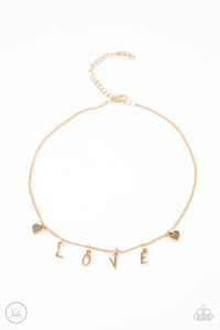 Nestled between a pair of dainty gold hearts, dangling gold letter charms spell out the word, "LOVE," creating a flirty fringe around the neck. Features an adjustable clasp closure.  Sold as one individual choker necklace. Includes one pair of matching earrings.