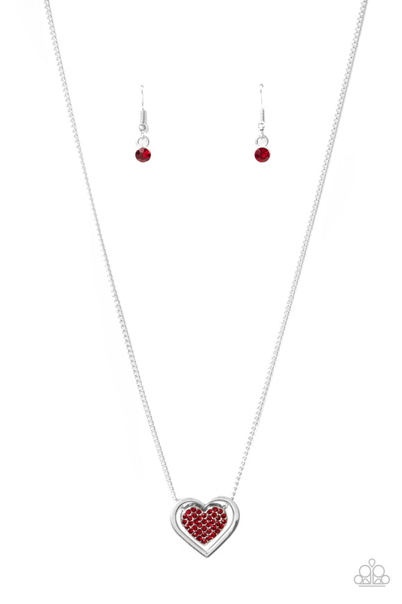 Bordered in a shiny silver frame, a red rhinestone encrusted silver heart is suspended below the collar of a gorgeously romantic look. Features an adjustable clasp closure. Sold as one individual necklace. Includes one pair of matching earrings.  Sold as one individual necklace. Includes one pair of matching earrings.