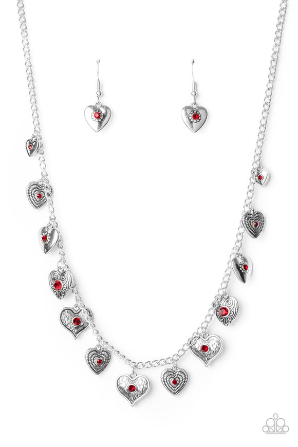 Dotted with fiery red rhinestone centers, a mismatched collection of silver heart frames swing from a dainty silver chain below the collar, creating a flirtatious fringe. Features an adjustable clasp closure.  Sold as one individual necklace. Includes one pair of matching earrings.